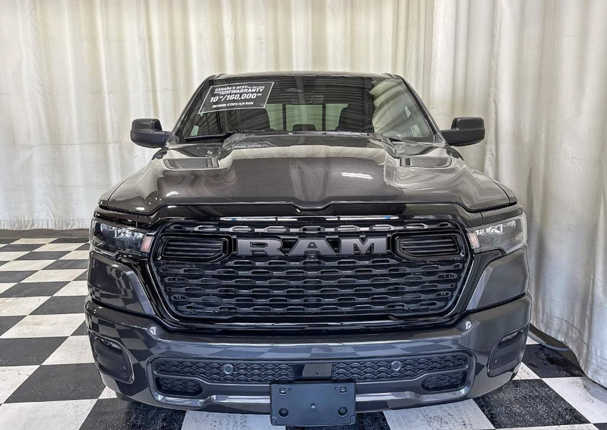grey 2026 Ram 1500 Express Crew Cab seen head on in the Dunn Ram Trucks photo booth