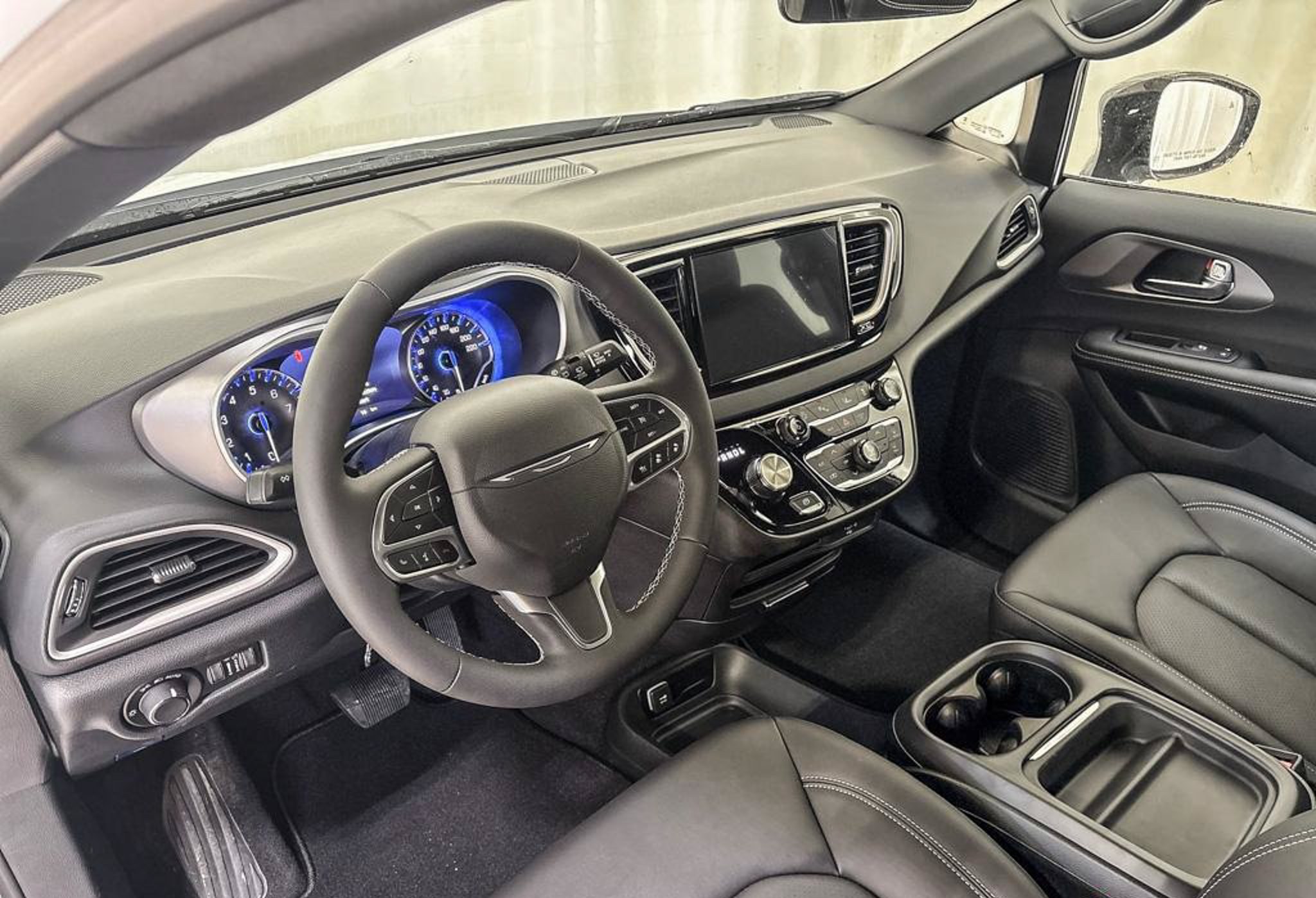 2027 Chrysler Grand Caravan SXT dash, front seats and touchscreen, studio photo of a Dunn Ram Trucks unit