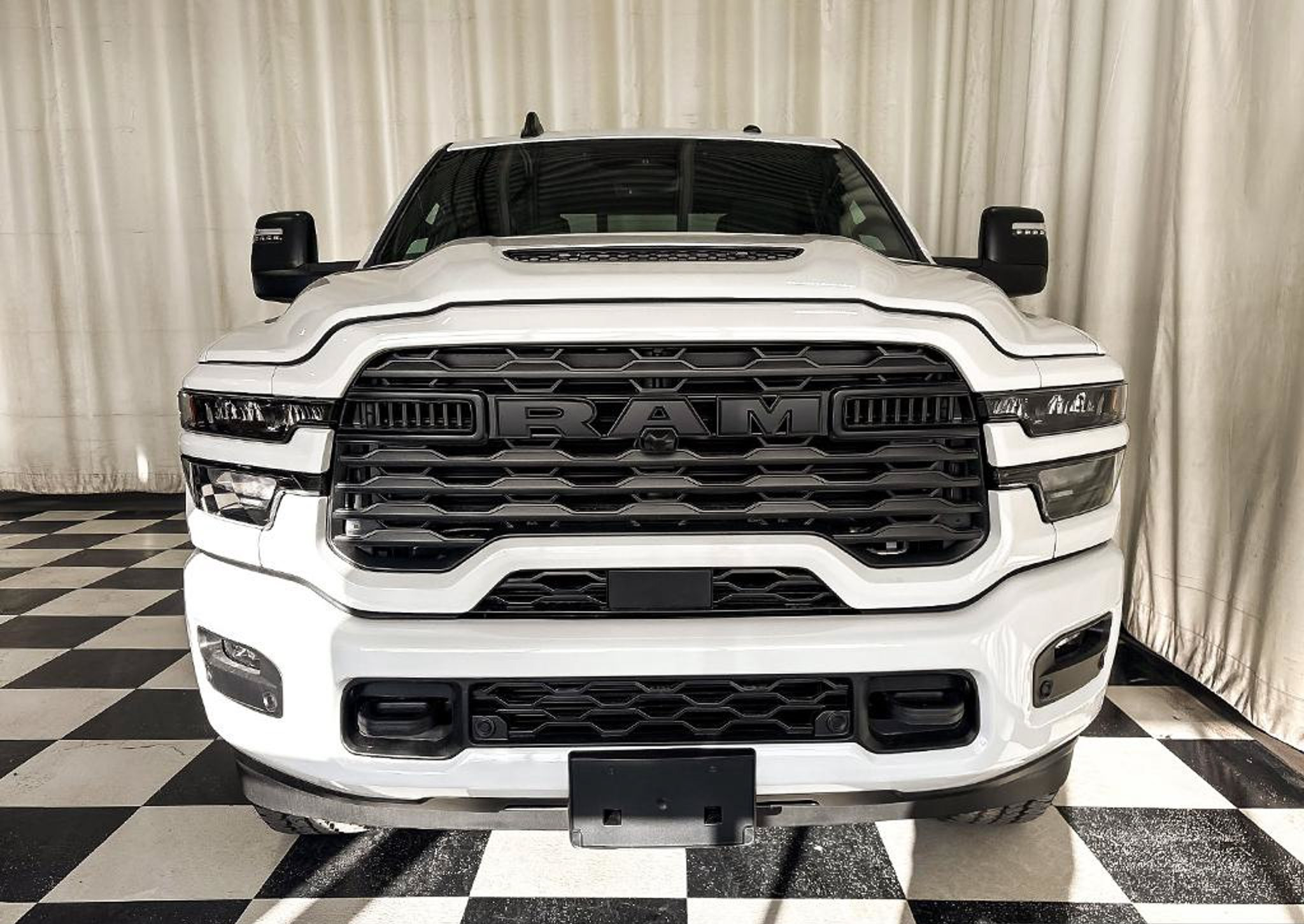 2027 Ram 2500 Black Express Crew Cab with the black grille insert and Sport Performance hood, studio photo of a Dunn Ram Trucks unit