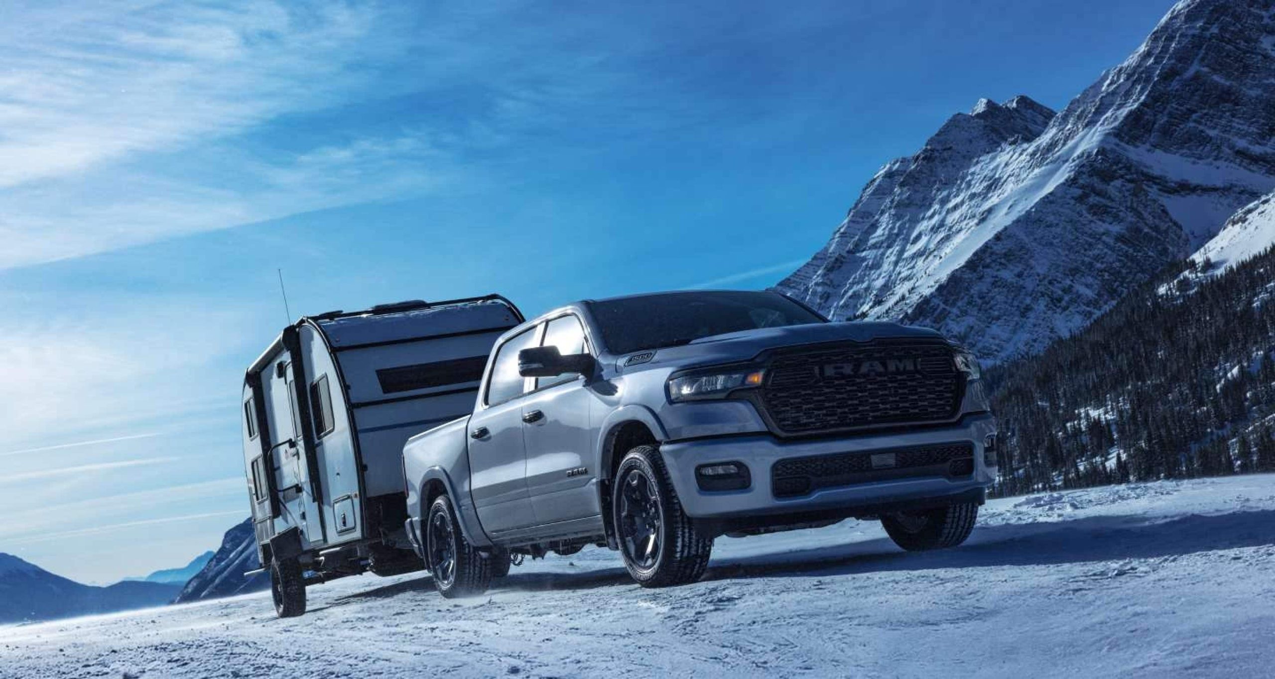 2027 Ram 1500 Big Horn towing a travel trailer in the snow, Ram's 2027 image