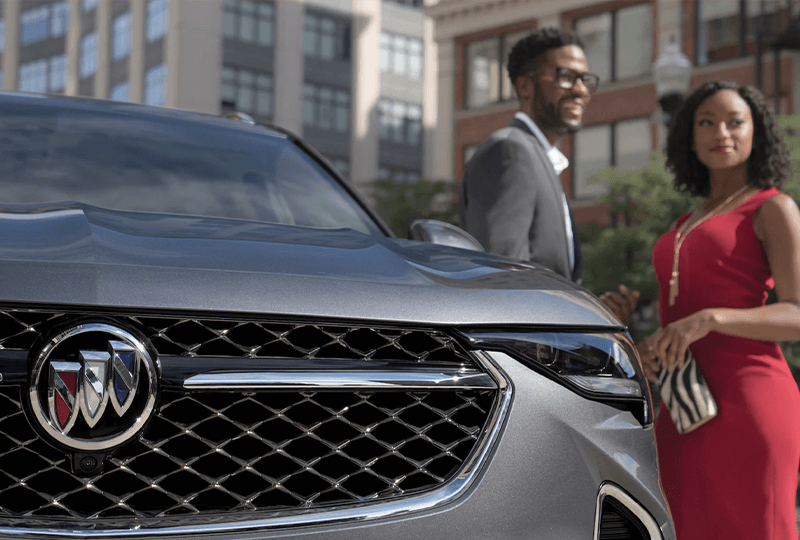 A couple beside a 2023 Buick Envision