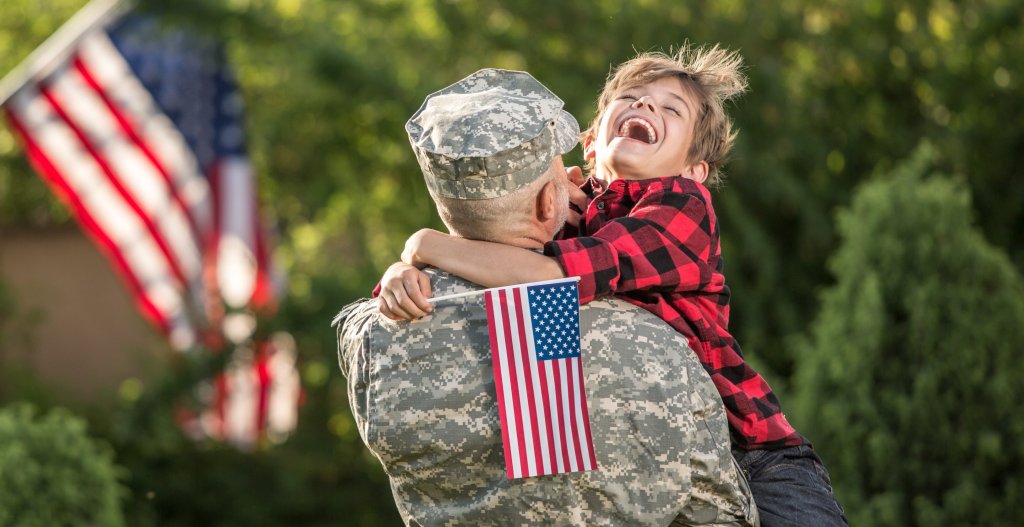 Veteran holding his smiling child in his arms