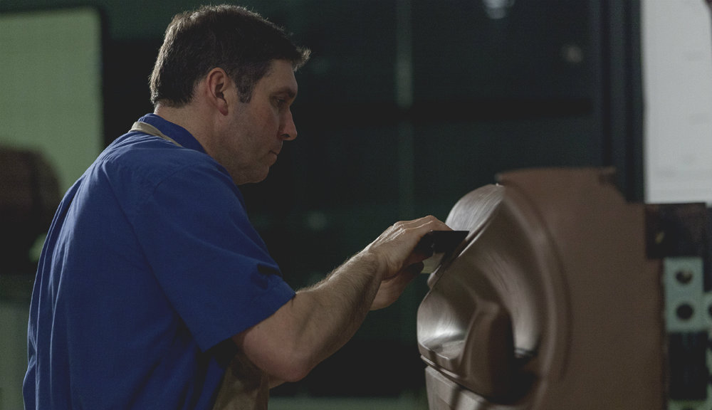 man sculpting a car's interior in clay