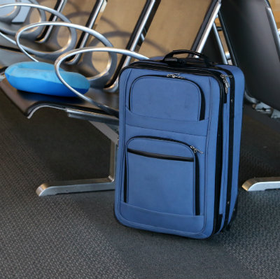 blue suitcase in a transport station signifying people on the move