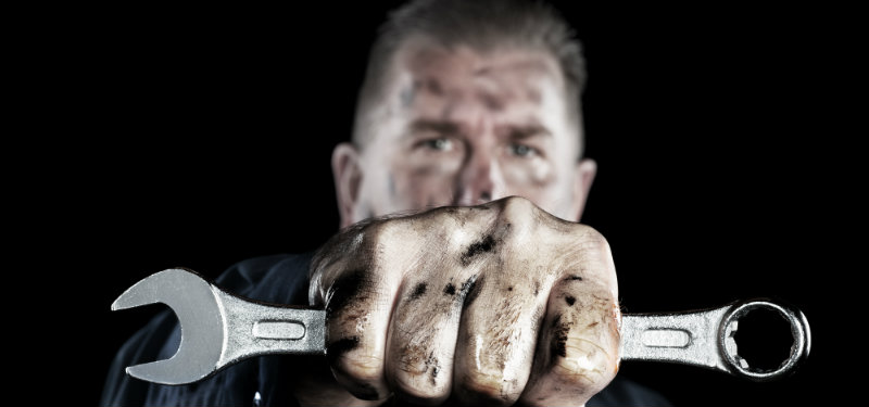 Mechanic holding a wrench with determination 