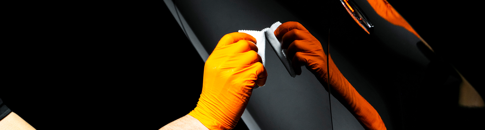 Detailer detailing black vehicle door