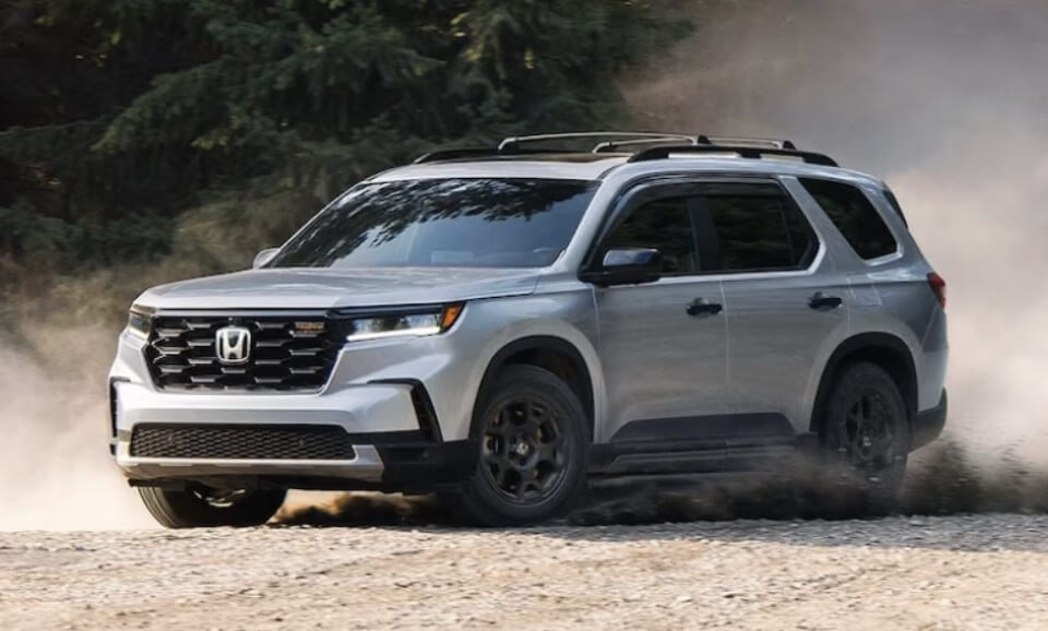 A silver 2024 Honda Pilot is seen driving off-road, making this Honda SUV the perfect adventurer for the entire family. Shop for your Honda Pilot at Midlands Honda in Columbia, SC.