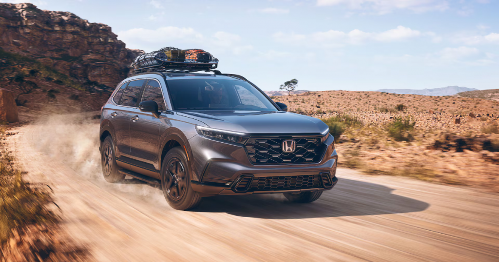 A Honda CR-V in Meteorite Gray Metallic drives on a dusty desert road.