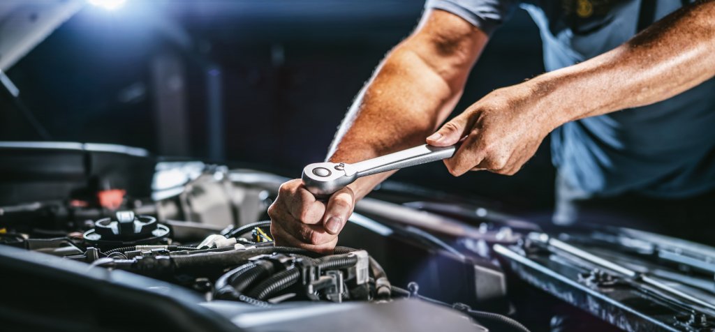 Mechanic working on the engine of a Nissan