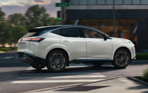 A white Nissan Murano turns a city corner. 