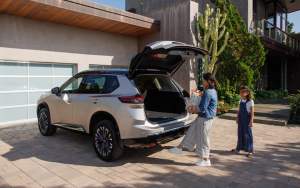 A mother and her daughter access the 2025 Nissan Rogue cargo space using the power tailgate.