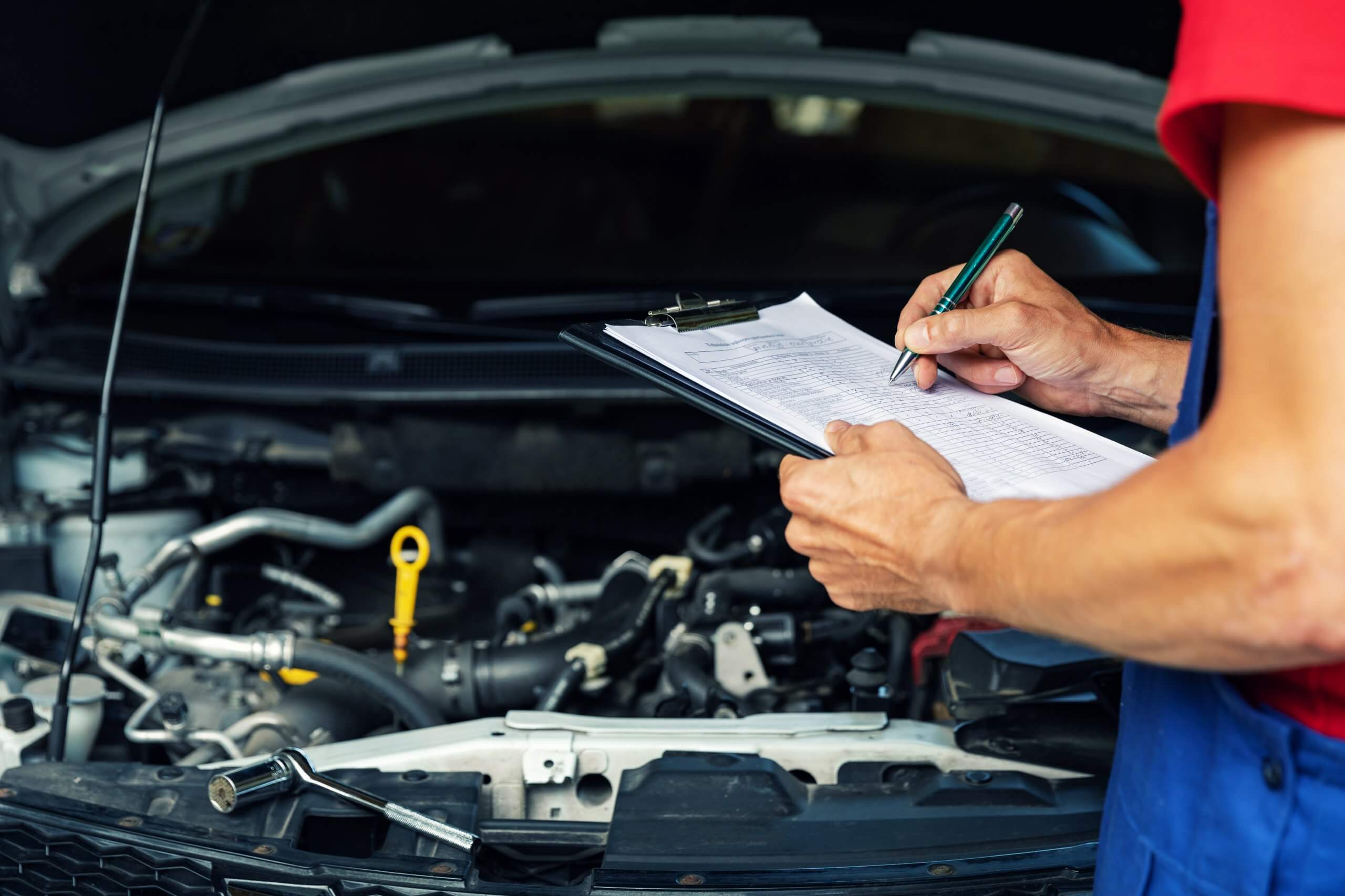 Mechanic checking an engine with a checklist