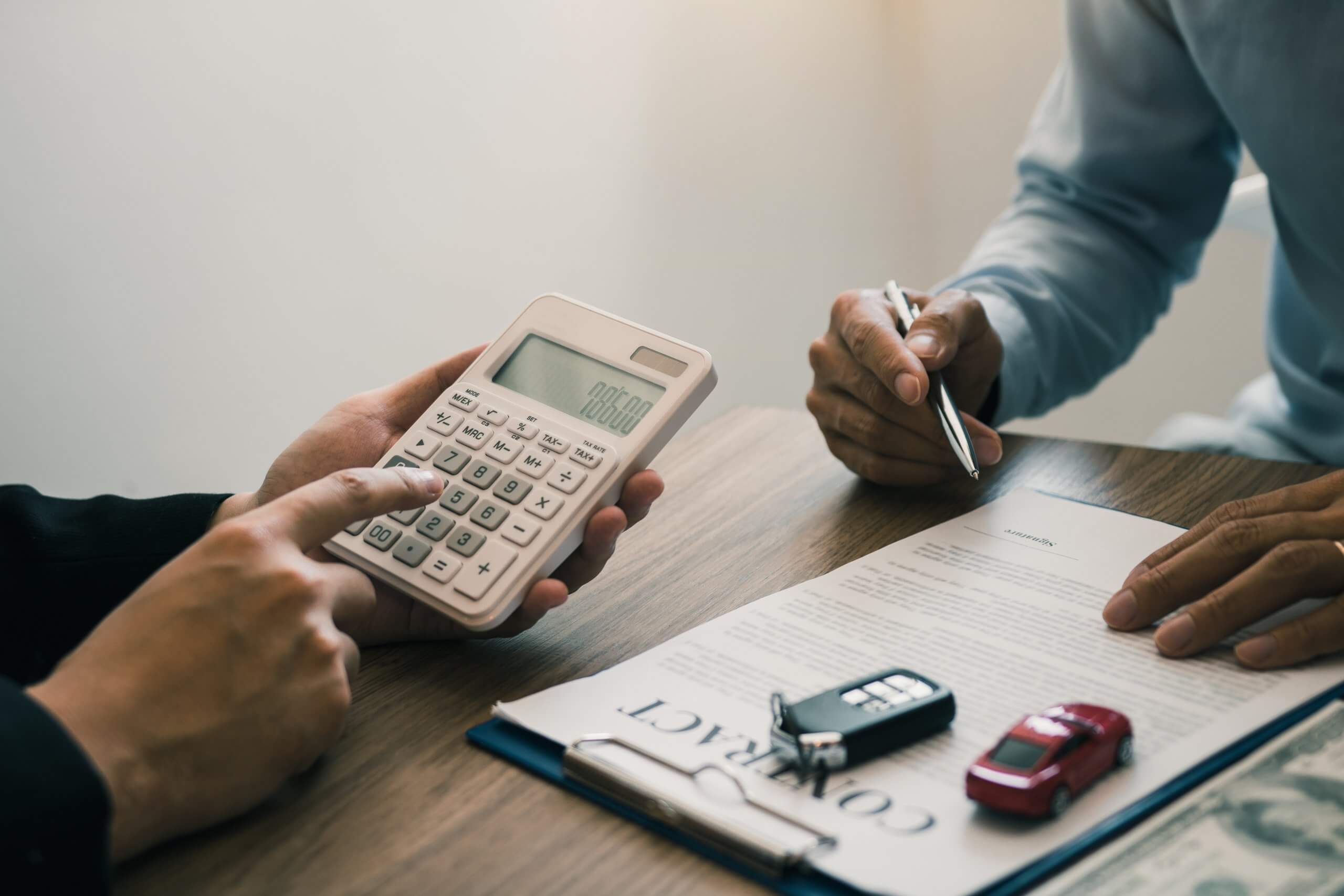 People calculating financing of a used car