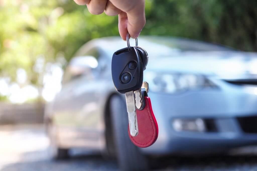 The car owner is standing the car keys to the buyer. Used car sa
