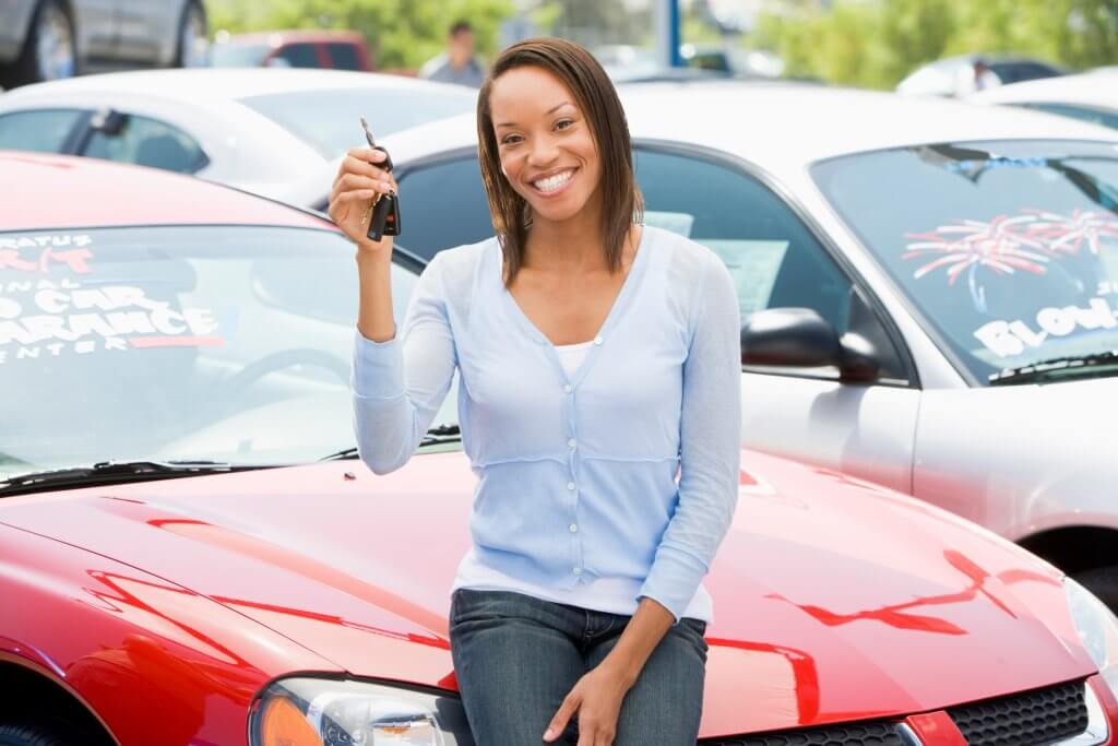 smiling black lady hugs her new auto
