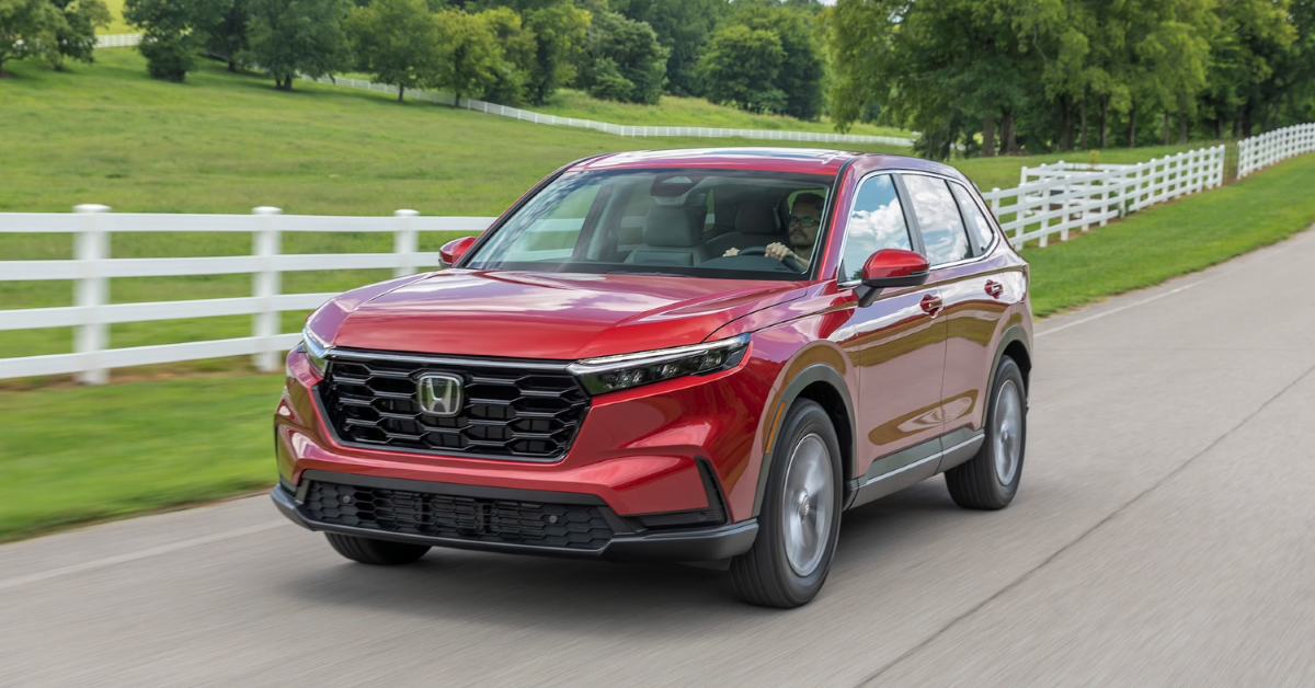 2025 Honda CR-V driving past a white picket fence in a field