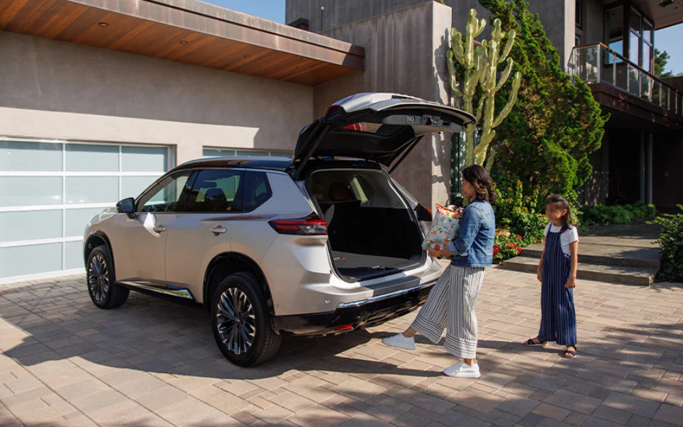 A mother and daughter load items into the back of a 2025 Nissan Rogue. 