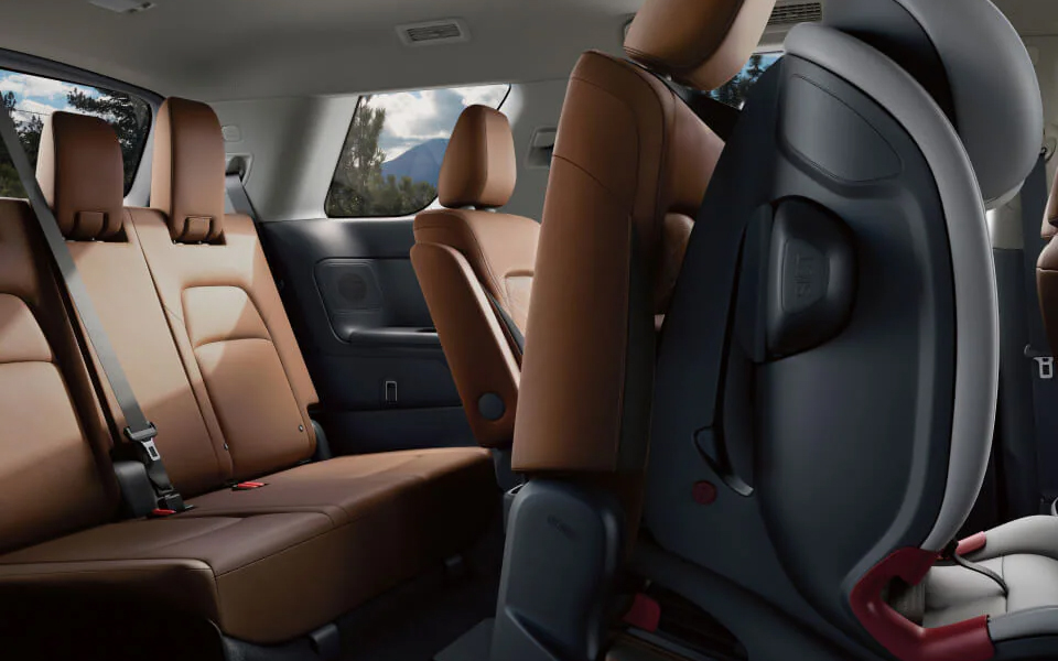 Interior view of the Nissan Pathfinder showcasing its spacious cabin with brown leather seats and a foldable second-row seat for easy access to the third row.