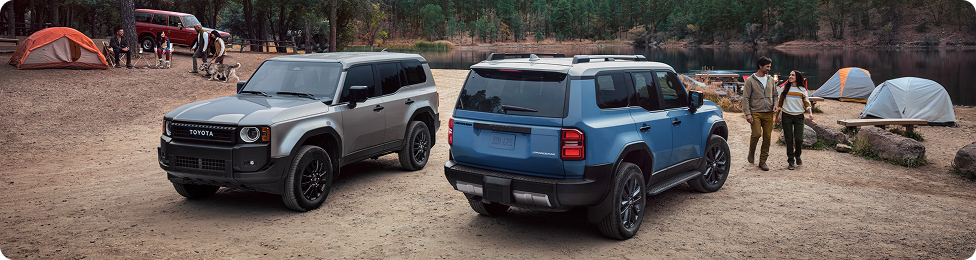 Two Toyota SUVs parked at a desert campsite with tents