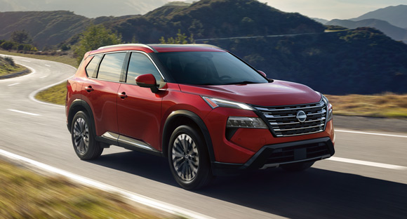 White SUV driving through desert landscape with mountains in background