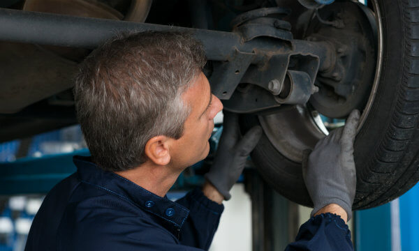 Mechanic looking at wheel and axel