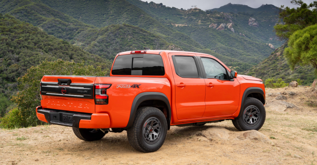 Red 2025 NIssan Frontier parked on rough road.