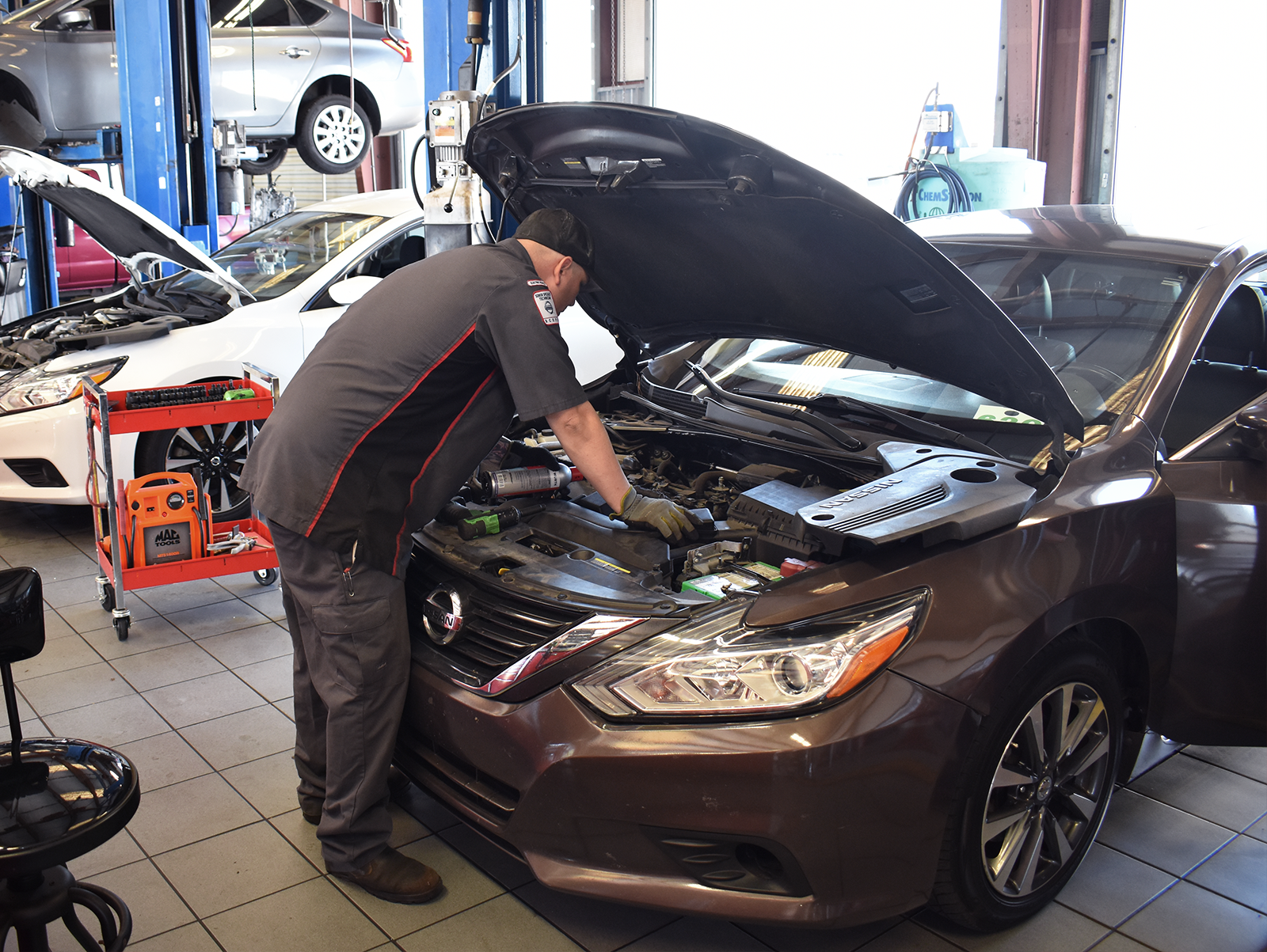 Nissan Service technician testing the tire treads on a vehicle