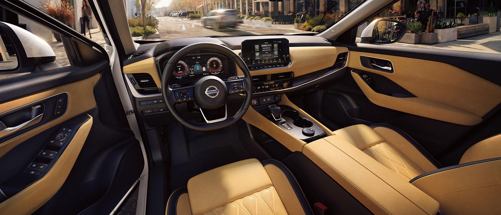 Interior view of the front seats and dashboard of a Nissan Rouge.