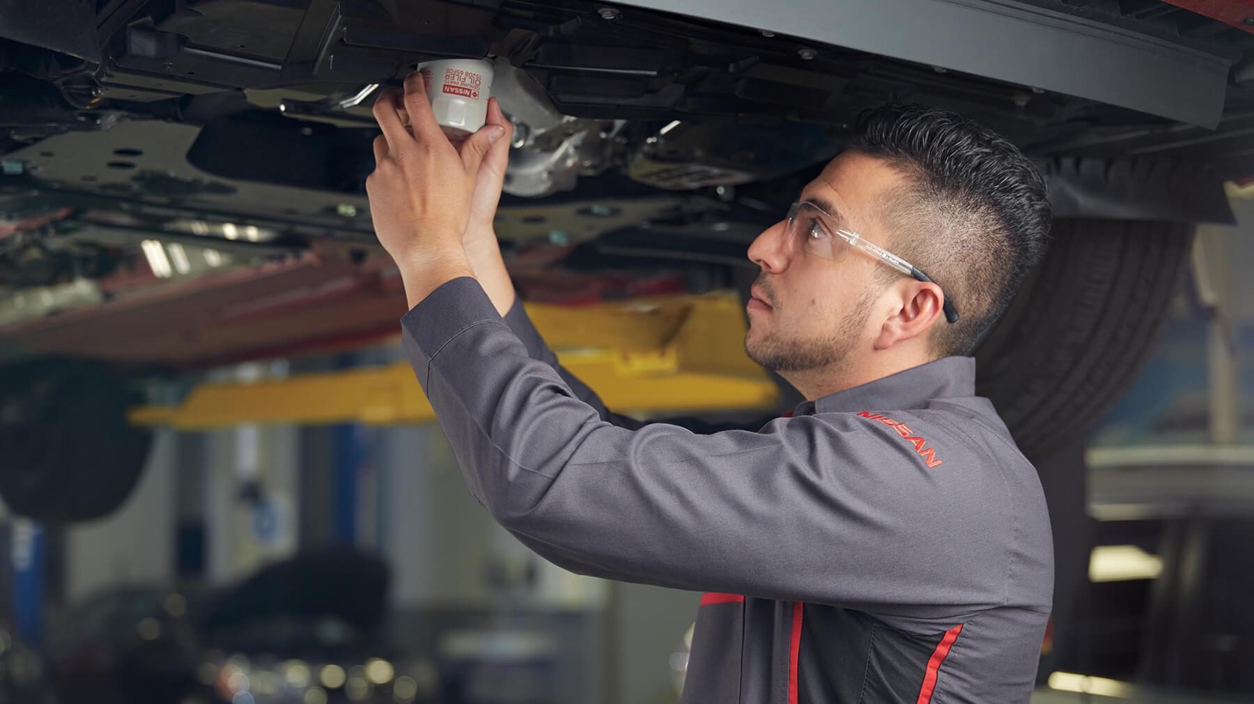 Nissan Technician Changing the Filter on Vehicle