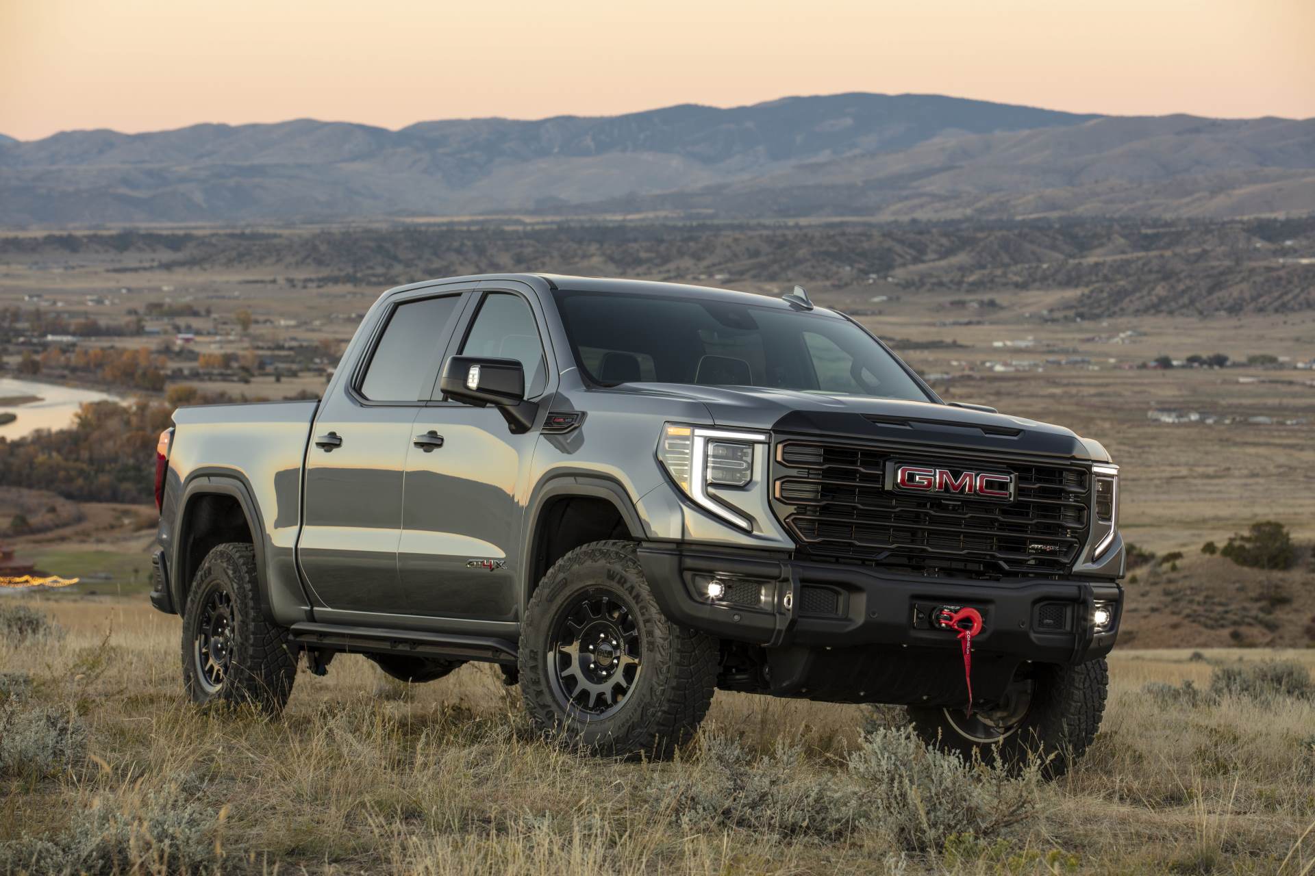 A GMC Sierra 1500 AT4X AEV edition off-road in 3/4 profile at dusk in Alberta foothills