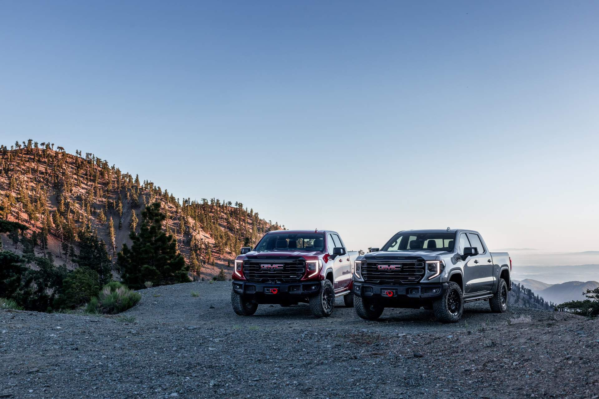 A pair of new GMC Sierra 1500 AT4X models sitting by lake