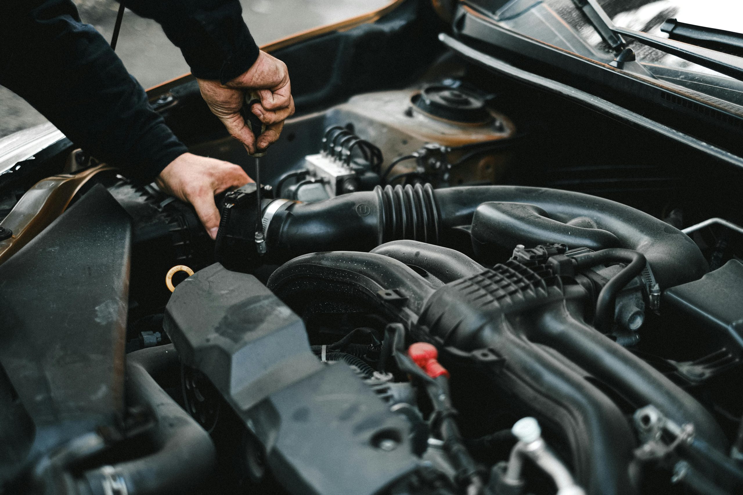 A mechanic at Summit GM working on the engine of a GMC Yukon