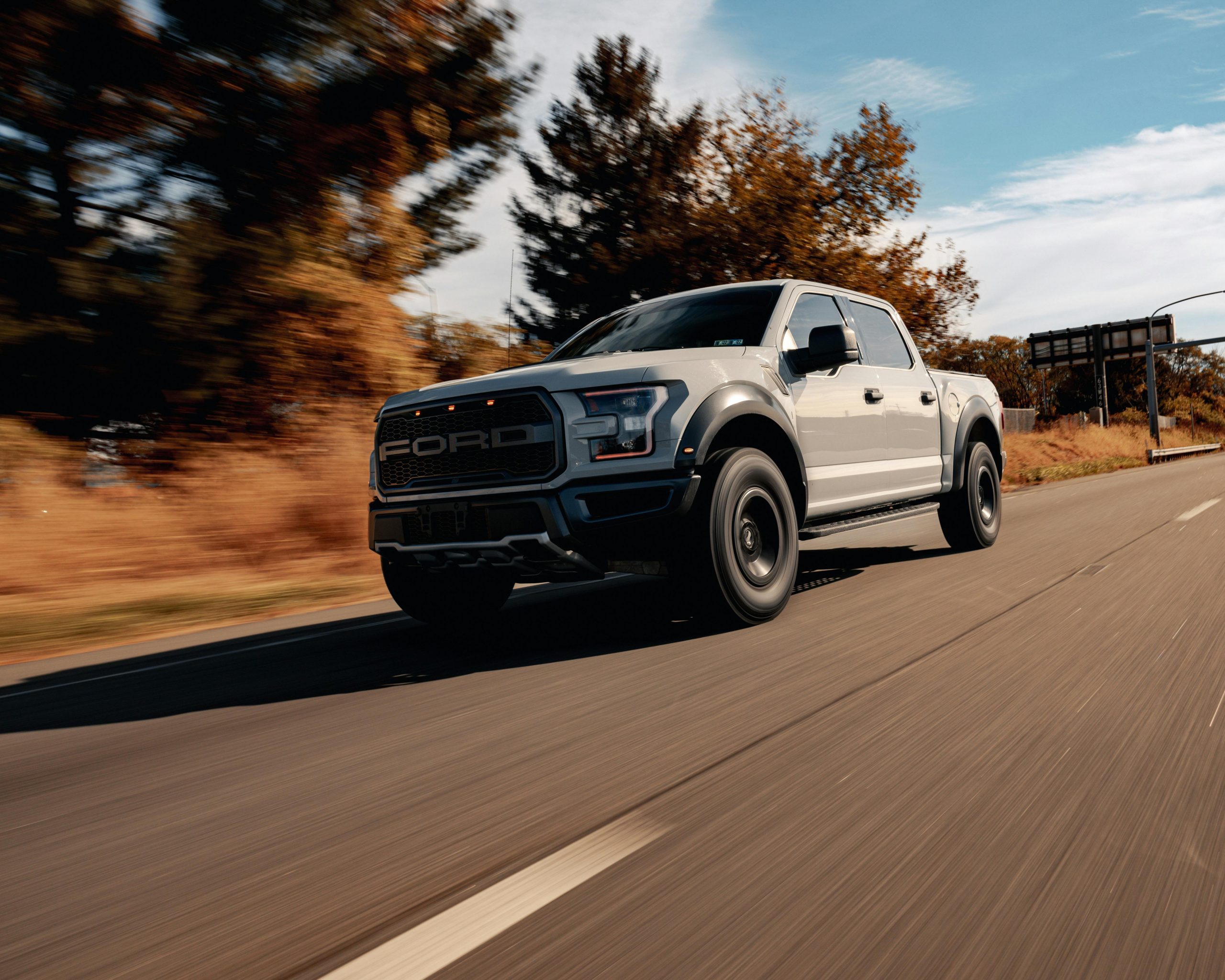 The Ford F-150 Raptor speeding along a highway.