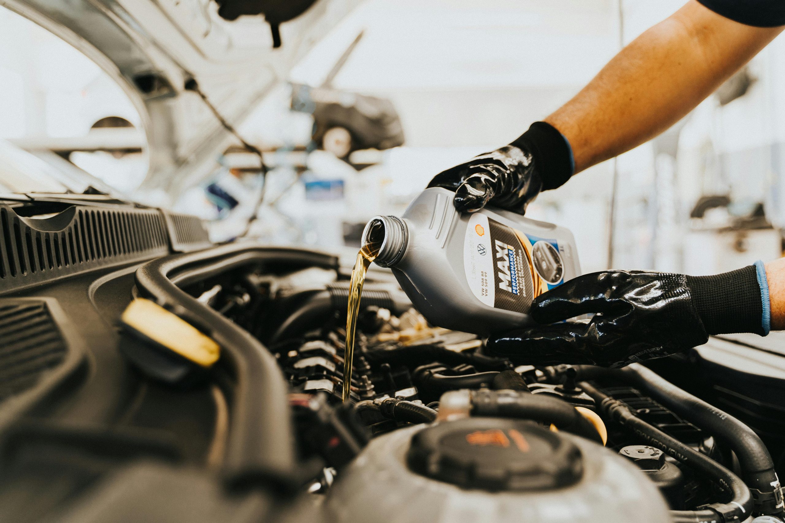 A technician pouring oil into the engine of a Chevrolet Silverado