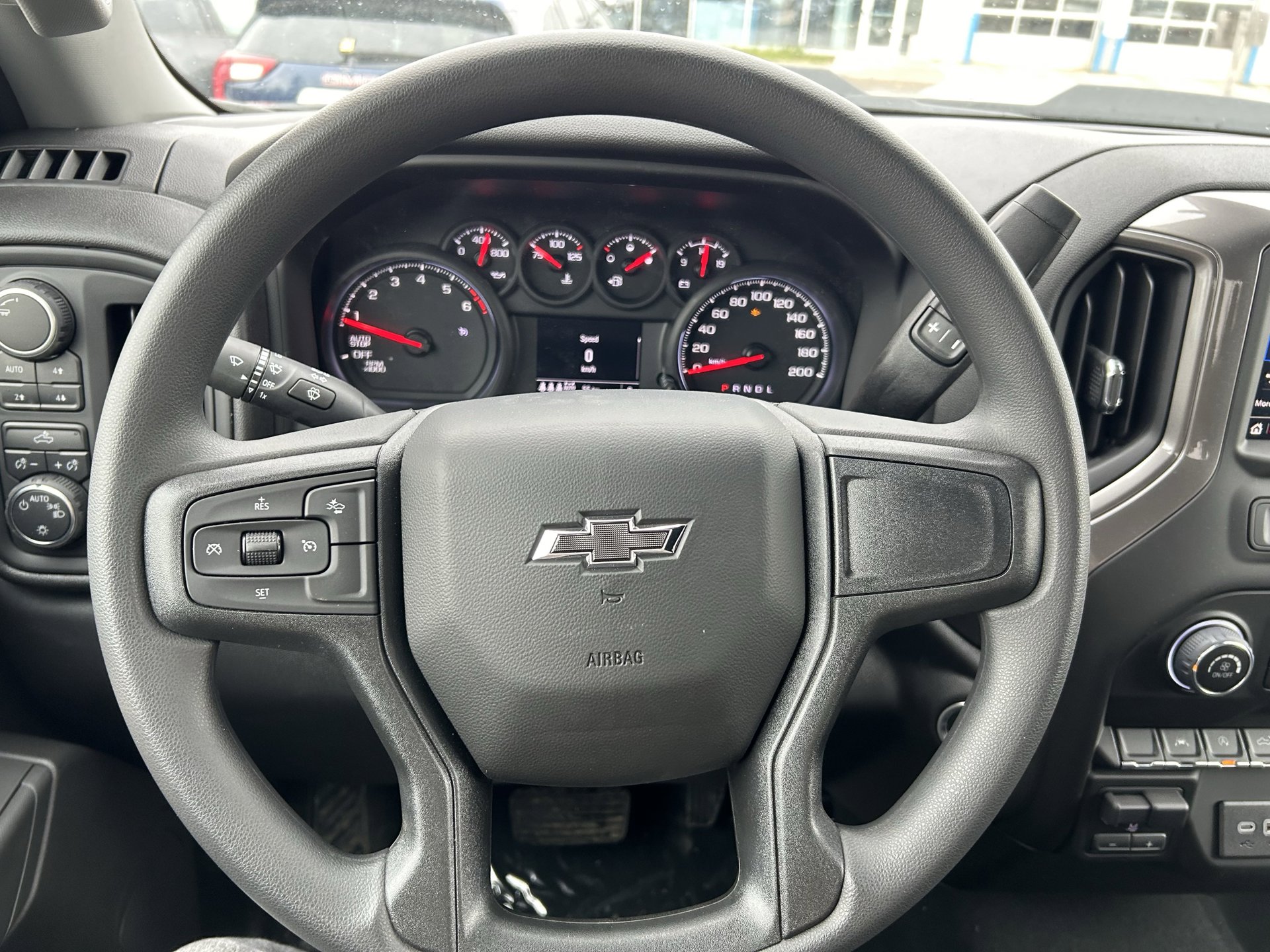 View of the steering wheel of a 2025 Chevrolet Silverado, highlighting its range of infotainment and interior safety features