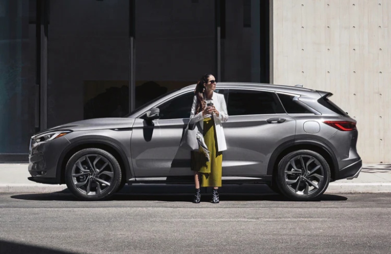 2021 INFINITI QX50 silver side view with woman in yellow