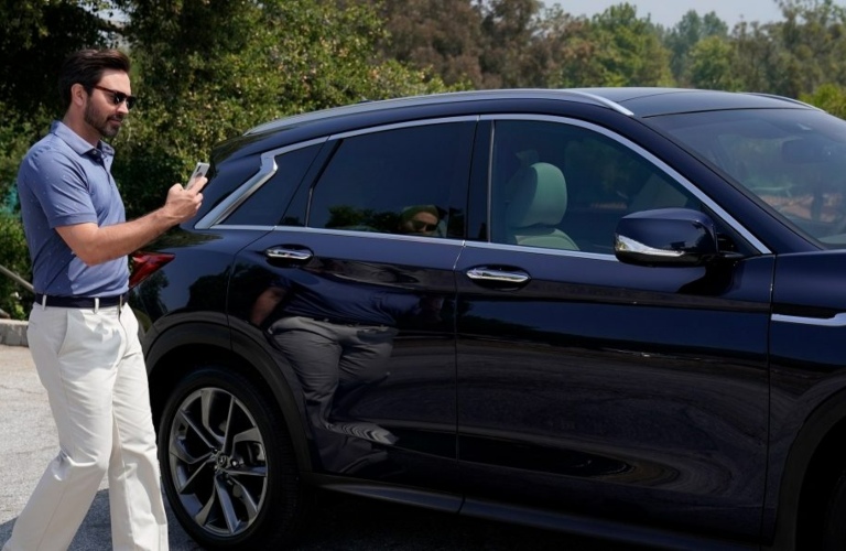 Guy walking up to an INFINITI SUV