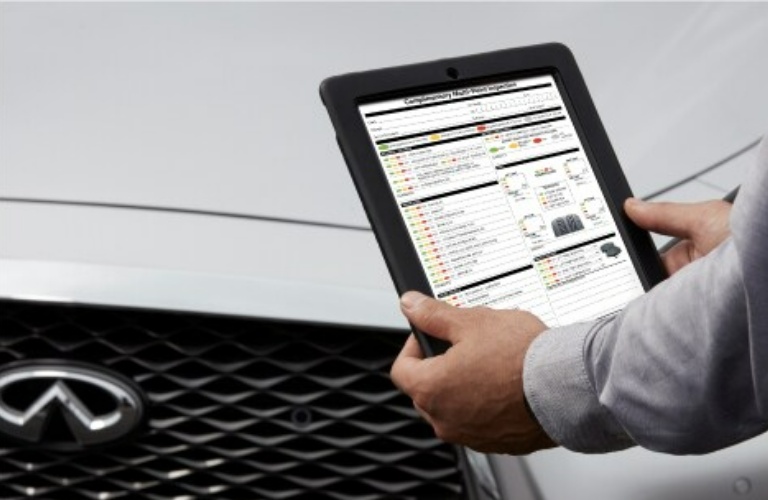 INFINITI Technician looking at an inspection sheet