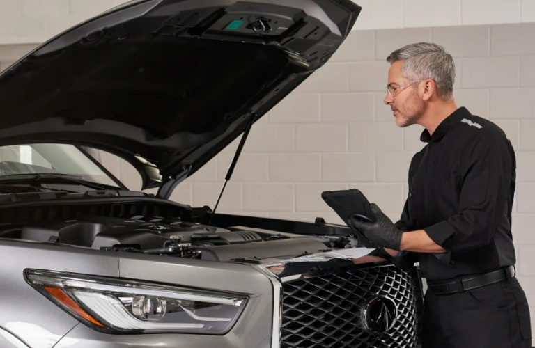Technician checking under the hood of an INFINITI