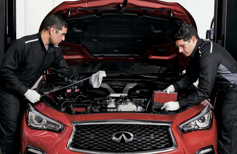 Technicians checking oil on an INFINITI