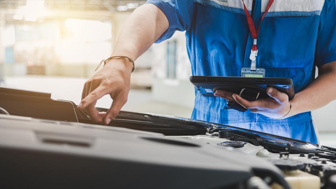 service technician pointing at vehicle