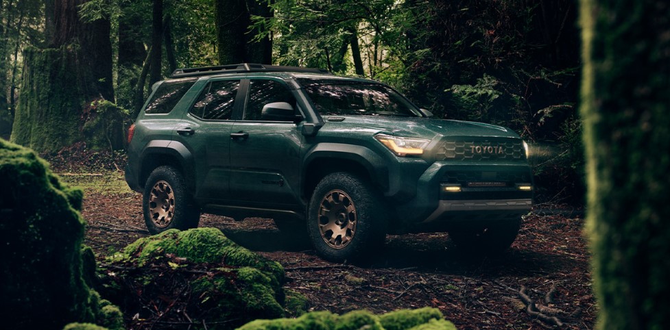 A new 2025 Toyota 4Runner traverses through a forest.