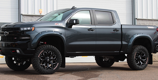 Dark blue Silverado parked by shop doors