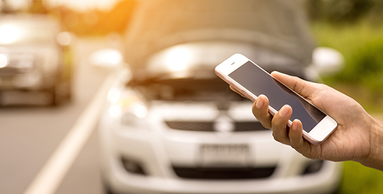 Person on cell phone with broken down car