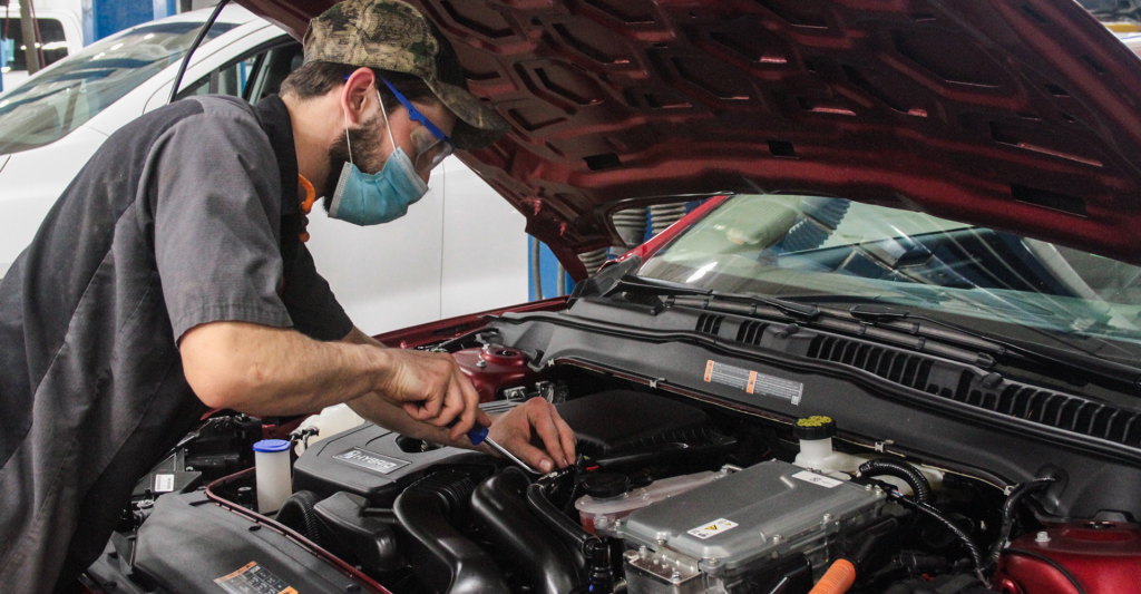 Mechanic working under hood of car