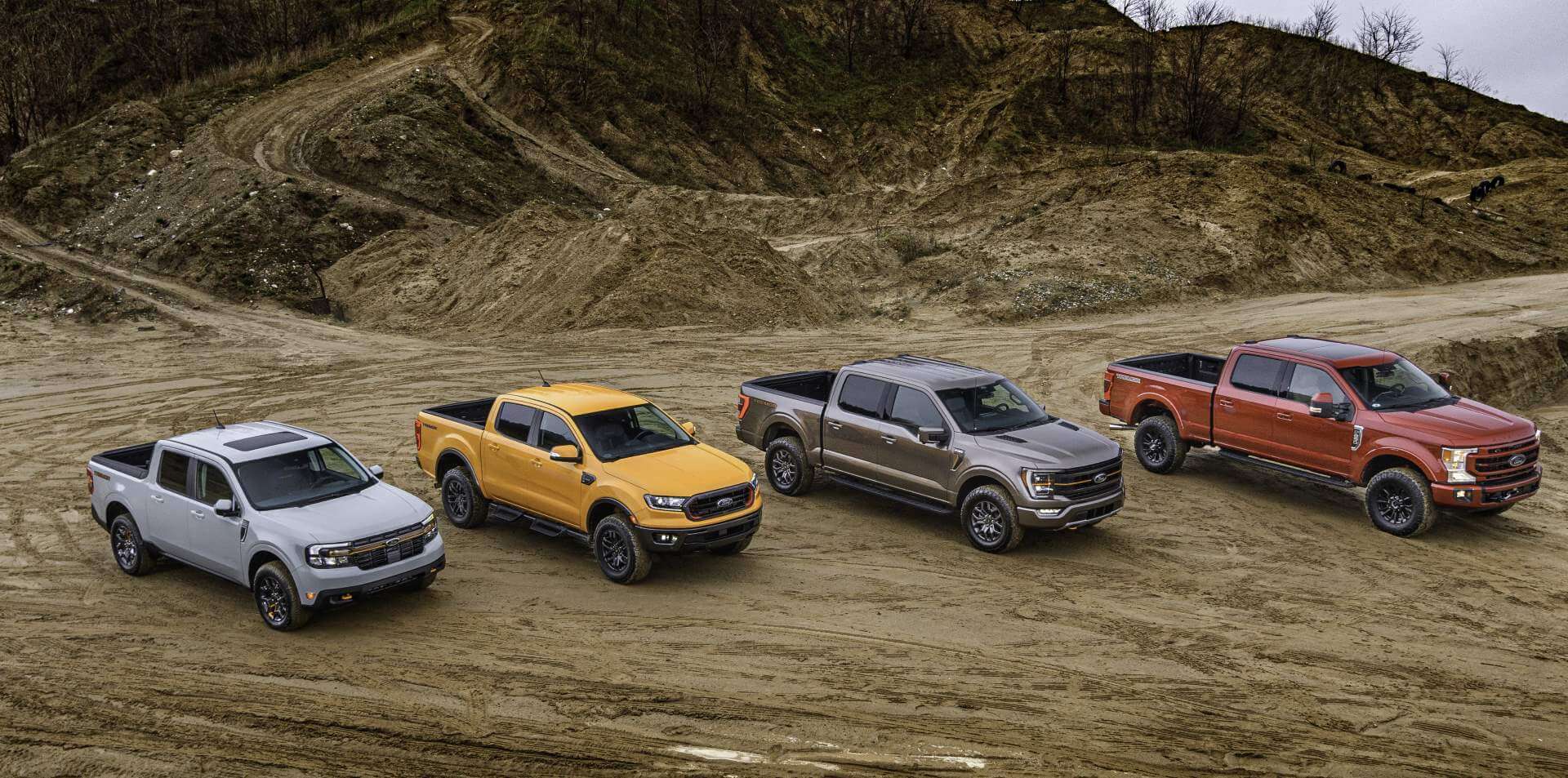 Fords F150, Ranger and more all in the Tremor trim on a dirt road at a worksite with dirt piled high behind