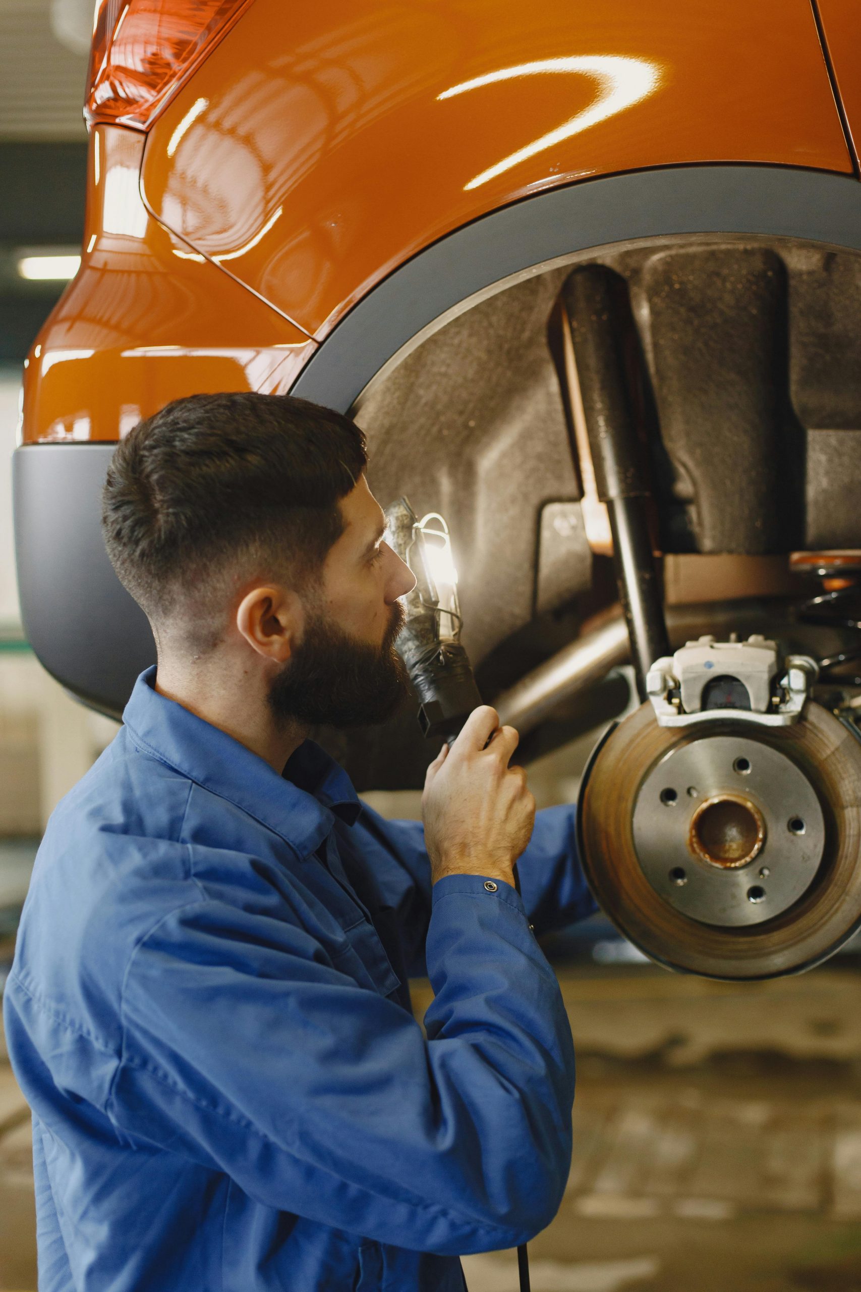 A mechanic inspecting brake pads and brake system components.