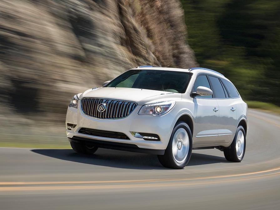 2017 Buick Enclave exterior white vehicle driving around curve near mountain. 