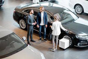 Business-couple-with-salesperson-in-the-car-showroom