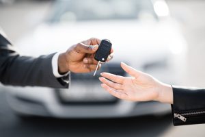 Car-Salesman-Handing-Over-Keys-to-New-Owner
